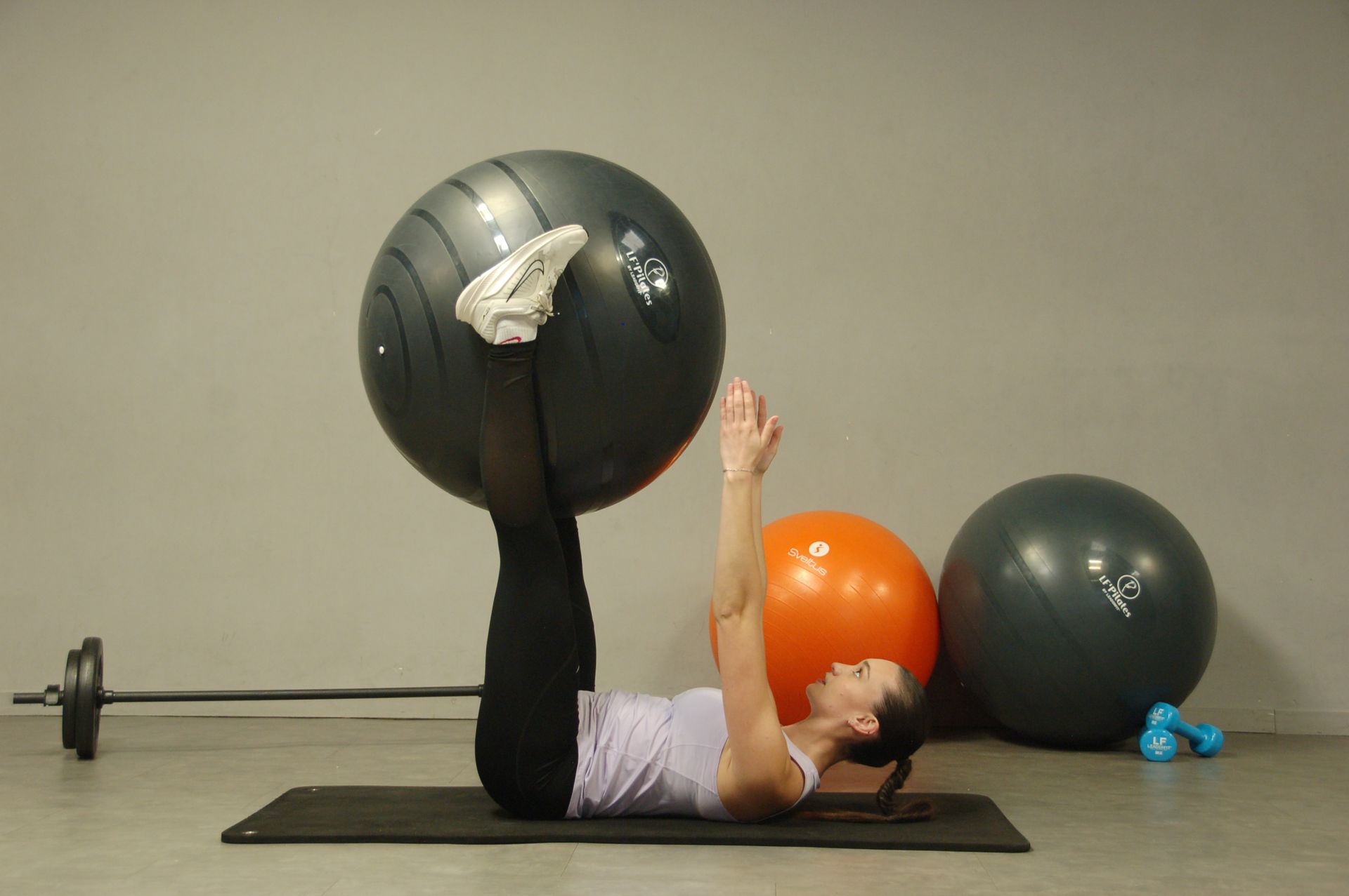 Exercice de gainage au sol, jambes en appui sur un ballon de gym, lors d'une séance de renforcement doux